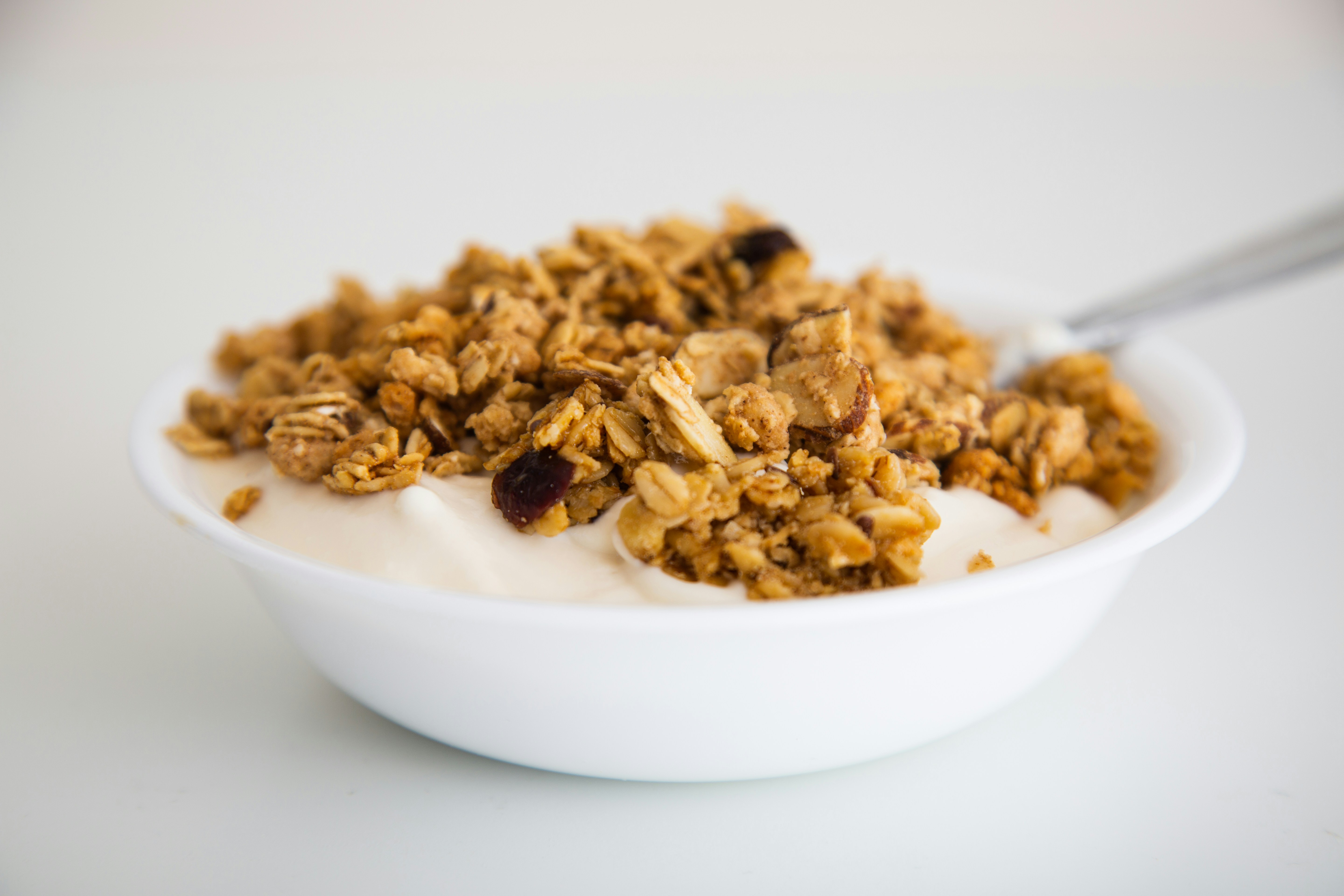 Protein parfait with layers of Greek yogurt, mixed berries, and granola in a clear glass showing beautiful layers